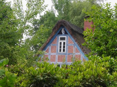 ein kleines Haus mit einem Strohdach und einem Fenster in der Unterkunft Weidenhoff in Worpswede