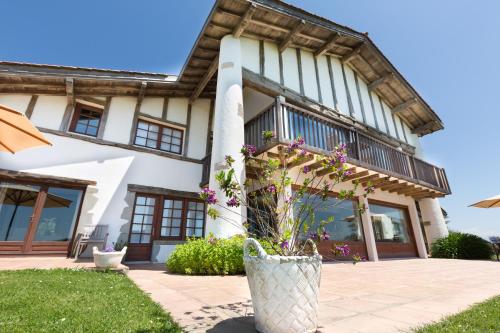 une maison avec un vase et des fleurs devant elle dans l'établissement La Maison Tamarin, à Saint-Jean-de-Luz