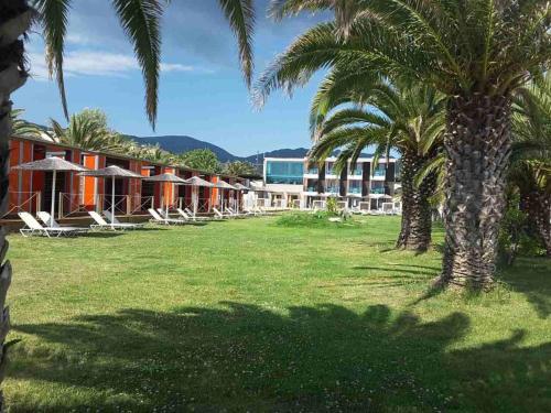 a resort with palm trees and lounge chairs in a field at THALASSA BOUTIQUE HOTEL in Sarti