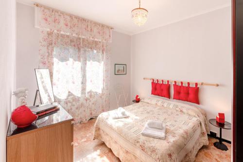a bedroom with a large bed with red pillows at [Free Parking] Un angolo di sole a MareBu! in Rapallo
