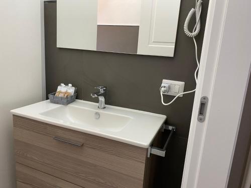 bagno con lavandino bianco e specchio di Residenza Segrate Centro Novegro a Segrate