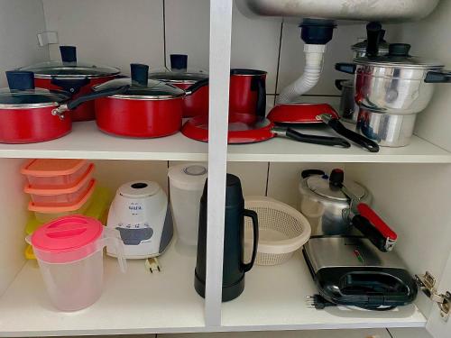 a shelf with pots and pans and other kitchen items at Apartamento Lótus Ar Cond Pertinho FIG e Centro in Garanhuns