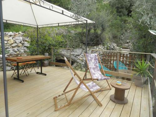 a wooden deck with a table and chairs on it at Chalet Zenitude in Breil-sur-Roya