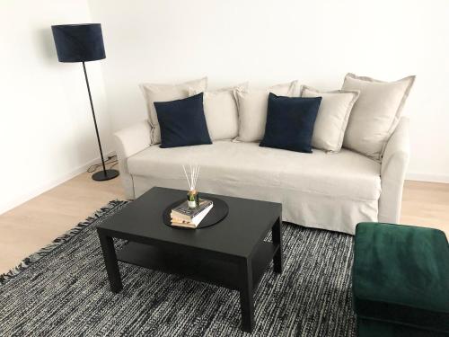 a living room with a white couch and a black coffee table at Modernūs apartamentai Šilutėje in Šilutė