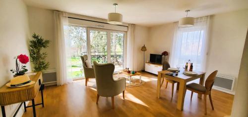 un salon avec une table et des chaises et une salle à manger dans l'établissement Résidence de Mons en Baroeul, à Mons-en-Baroeul