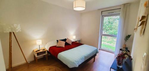 1 dormitorio con 1 cama con manta roja y ventana en Résidence de Mons en Baroeul, en Mons-en-Baroeul