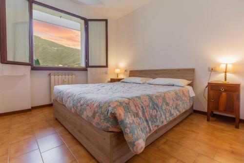 um quarto com uma cama grande e uma janela em Val Taleggio nel verde x8 persone con camino e Wifi em Olda