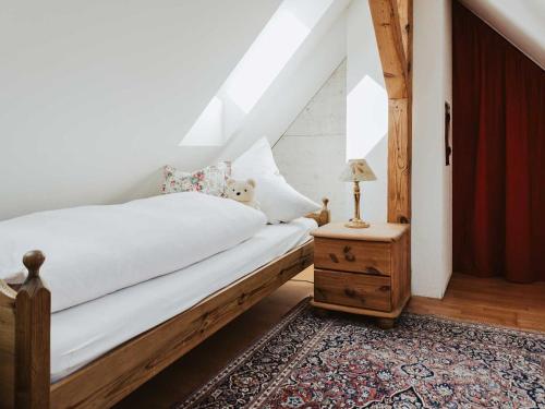 a bedroom with a bed and a table with a lamp at Ferienwohnung Bodenseeblick in Allensbach