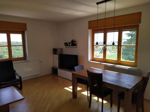 ein Wohnzimmer mit einem Tisch, Stühlen und einem TV in der Unterkunft Raus aufs Land in Ederberg