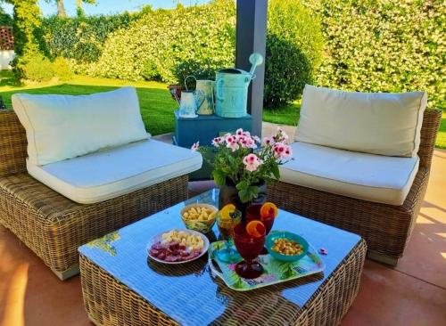 two wicker chairs and a table with food on a patio at Villa Albina in La Loggia
