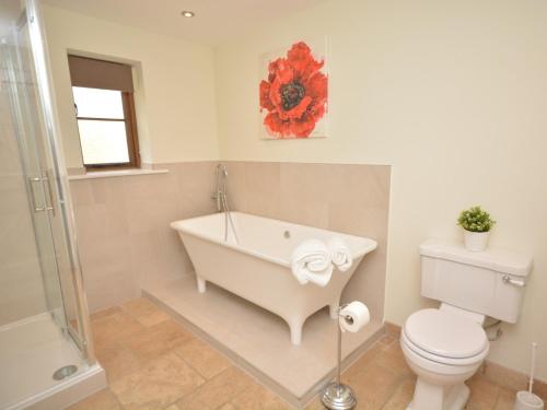 a bathroom with a bath tub and a toilet at 2 Bed in South Molton 62654 in Filleigh