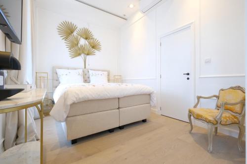 um quarto branco com uma cama e uma cadeira em Room Jade - La Maison de la duchesse de la Valliere - Parking privé em Mons