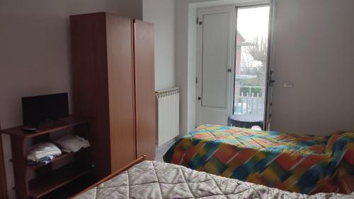 1 dormitorio con 1 cama, armario y ventana en Da Totonno, en Montefalcione