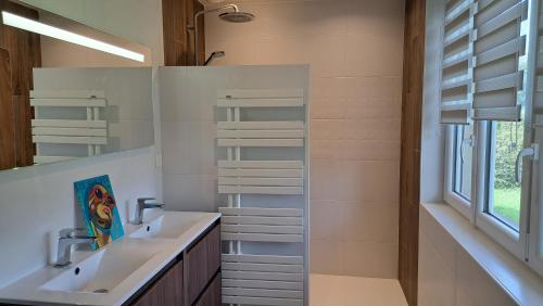 une salle de bain avec deux lavabos et un miroir dans l'établissement Maison proche plages du Débarquement, à Douvres-la-Délivrande