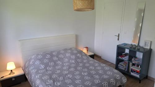 une chambre avec un lit et une table de chevet dans l'établissement Maison proche plages du Débarquement, à Douvres-la-Délivrande