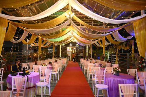 a banquet hall with purple tables and chairs at HOTEL SHOOLIN GRAND in Guwahati