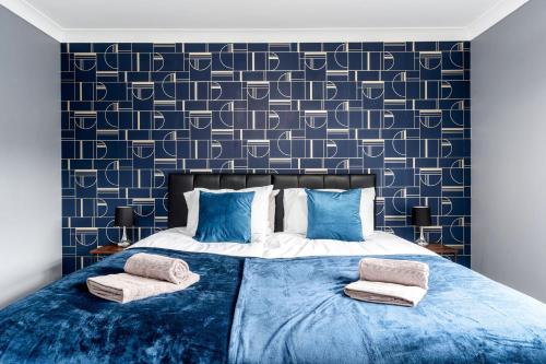 a bedroom with a blue bed with two pillows at Stylish House with Garden in Knottingly