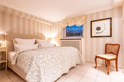ein Schlafzimmer mit einem Bett, einem Stuhl und einem Fenster in der Unterkunft Ferienwohnung Feskerdam in Morsum