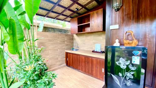 a kitchen with a refrigerator and some plants at NILUH Private Villas Ubud in Ubud