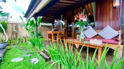 a patio with a couch and a table in a garden at NILUH Private Villas Ubud in Ubud