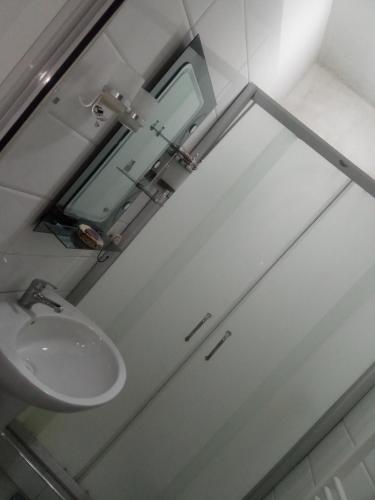 ein Bad mit einem Waschbecken und einem Spiegel in der Unterkunft Appartement pré du stade olympique belgaid in Canastel
