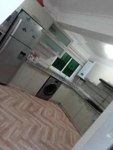 mit Blick auf eine Küche mit weißen Schränken in der Unterkunft Appartement pré du stade olympique belgaid in Canastel