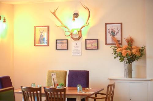 a dining room with a table and some antlers on the wall at The Devonshire Arms in Eckington