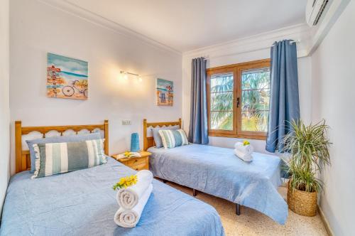 1 dormitorio con 2 camas y ventana en Blue Bay, en Alcudia