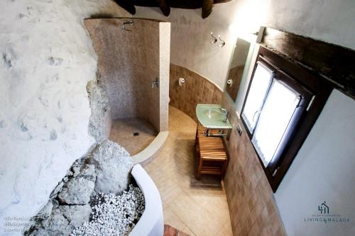 BenadalidにあるLiving4Malaga Villas Rurales Grazalemaのバスルーム(バスタブ、シンク付)、窓が備わります。