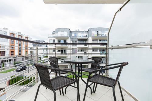 balcone con tavolo, sedie e vista sulla città di Studio Apartment Villa Mistral Świnoujście by Renters a Świnoujście