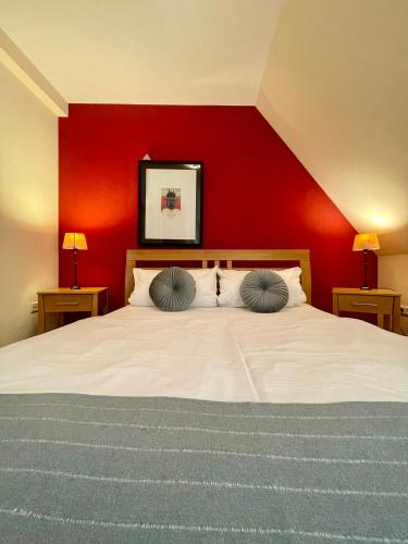 a bedroom with a white bed with a red wall at Hotel Schloss Zell in Zell an der Mosel
