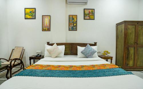 a bedroom with a large white bed with many pillows at Tripli Hotels GADH BANSIYA in Udaipur