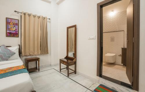 a bedroom with a bed and a mirror and a bathroom at Tripli Hotels GADH BANSIYA in Udaipur