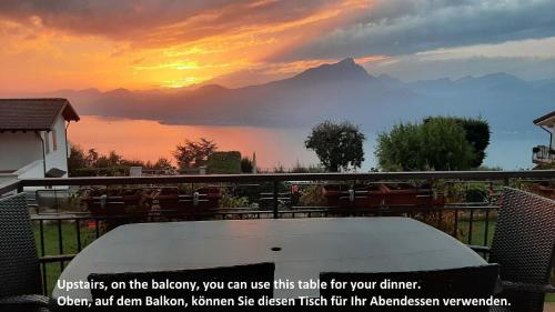 a table on a balcony with a view of a mountain at Nette Ferienwohnung in Le Camille mit Großem Garten in San Zeno di Montagna