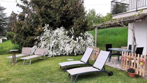 a group of chairs and tables in a yard at Nette Ferienwohnung in Le Camille mit Großem Garten in San Zeno di Montagna