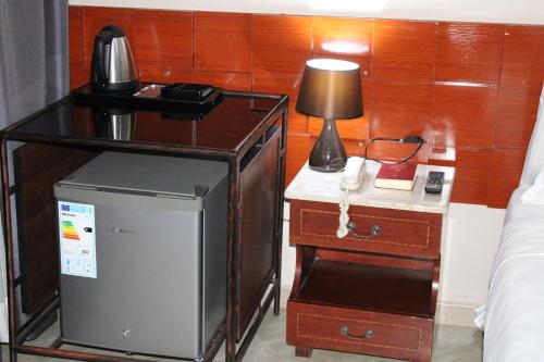Pokój z łóżkiem i biurkiem z telefonem w obiekcie ESCAPE VILLAGE HOTEL w mieście Yumbe