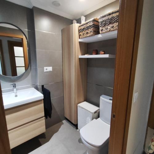 Un baño pequeño con inodoro y lavabo. en Piso céntrico en Viveiro con aparcamiento, en Viveiro