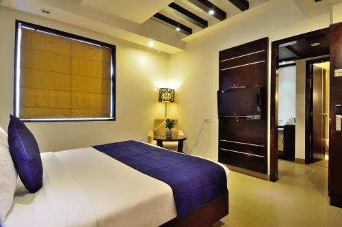 1 dormitorio con 1 cama grande y TV en Hotel Gross International near delhi airport en Nueva Delhi