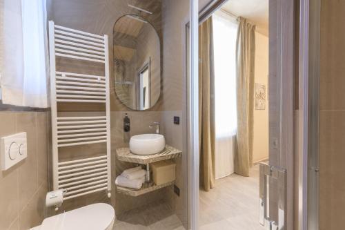 y baño con lavabo blanco y espejo. en Rooms Don Alfonso en Parma