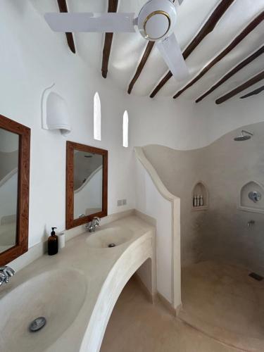 a bathroom with two sinks and a ceiling fan at Sea view house in Kilifi