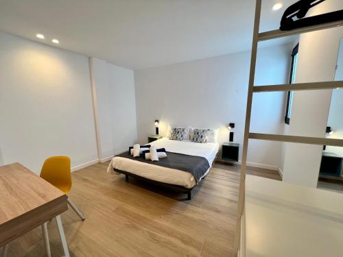 a bedroom with a bed and a desk and a ladder at La Cala de Alcalá Luxury in Alcalá