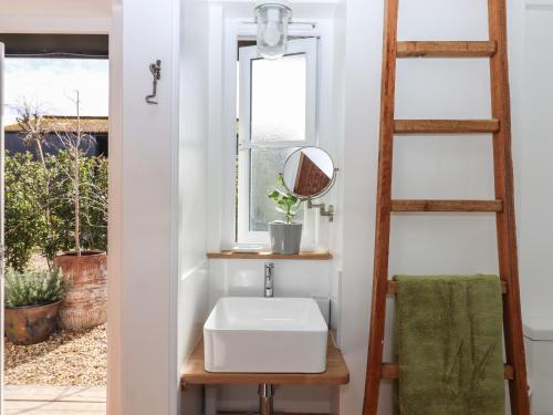 a bathroom with a sink and a window at The Apple Shed in Exeter