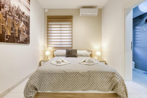 ein Schlafzimmer mit einem großen Bett mit zwei Handtüchern darauf in der Unterkunft GC1 - Lovely 2 Bed Apt in Gzira in Gżira