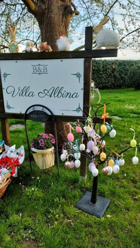 a sign with easter eggs on it in front of a tree at Villa Albina in La Loggia