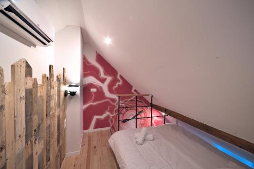- une chambre avec des lits superposés et un mur rouge dans l'établissement Retour vers le passé, à Metz
