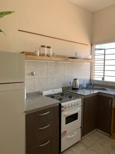 Il comprend une cuisine équipée d'une cuisinière et d'un four blanc. dans l'établissement Apartamento Entero en Ezeiza/ Canning, à Canning