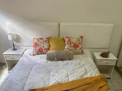 - un lit blanc avec des oreillers dans la chambre dans l'établissement Apartamento Entero en Ezeiza/ Canning, à Canning
