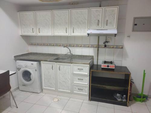 kuchnia ze zlewem i pralką w obiekcie Furnished Studio for Rent w Szardży