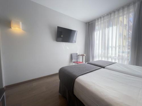 a bedroom with a bed and a flat screen tv at SM Hotel Sant Antoni in Barcelona