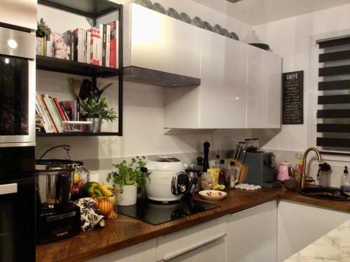 une cuisine avec des armoires blanches et un comptoir dans l'établissement Lovely flat near Paris, à Asnières-sur-Seine